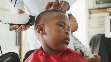 close view of african man cutting african boy hair