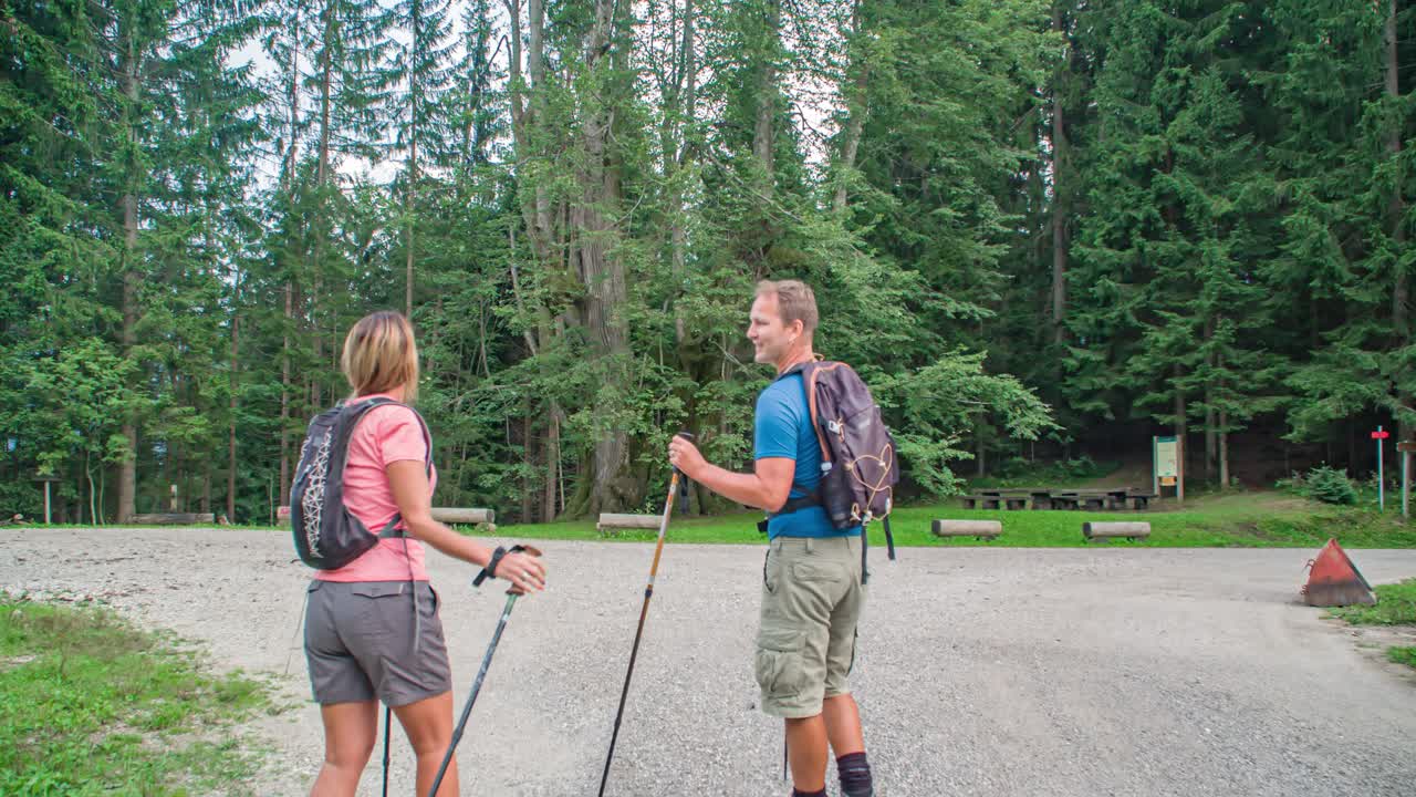Walking wanderer couple with hiking gear and backpack exploring surroundings Najevska linden tree