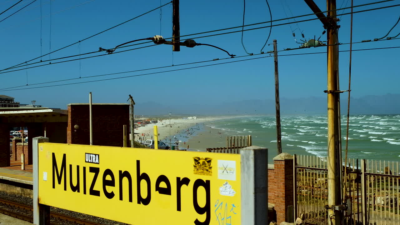 estación de tren muizenberg con vistas a la playa llena de bañistas