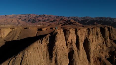 Man-At-Peak-Of-Red-Cliffs-In-Remains-Of-Shahr-e-Zuhak-Fortress-In-Bamyan,-Afghanistan