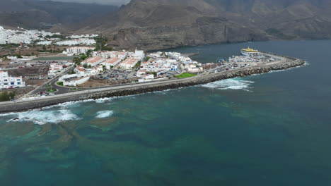 Maravillosa-Vista-Aérea-De-La-Costa-De-Agaete-Donde-Se-Pueden-Ver-Casas,-El-Puerto-De-Las-Nieves-Y-El-Ferry-Atracado