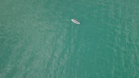 Bird’s-eye-view-of-a-woman-on-a-white-paddle-board-in-the-green-waters-of-the-Aegean-Sea