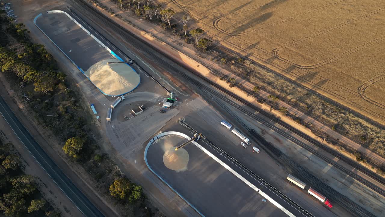 산업용 유통 장소에 도착하는 트럭의 공중 조류 눈 은 그리드에 곡물을 내리기 위해