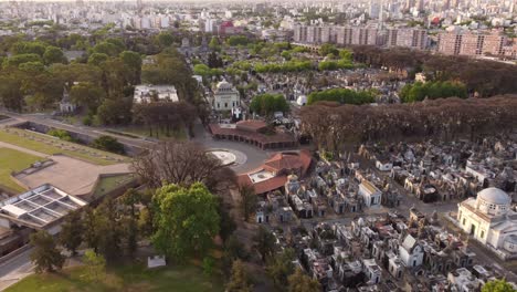 drone flying over church of chacarita cemetery with buenos aires cityscape in background