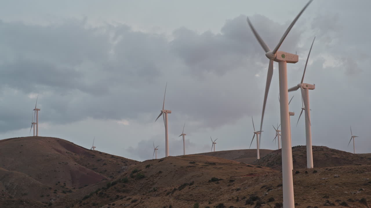 turbinas eólicas al atardecer en un paisaje montañoso cerca de patras, grecia