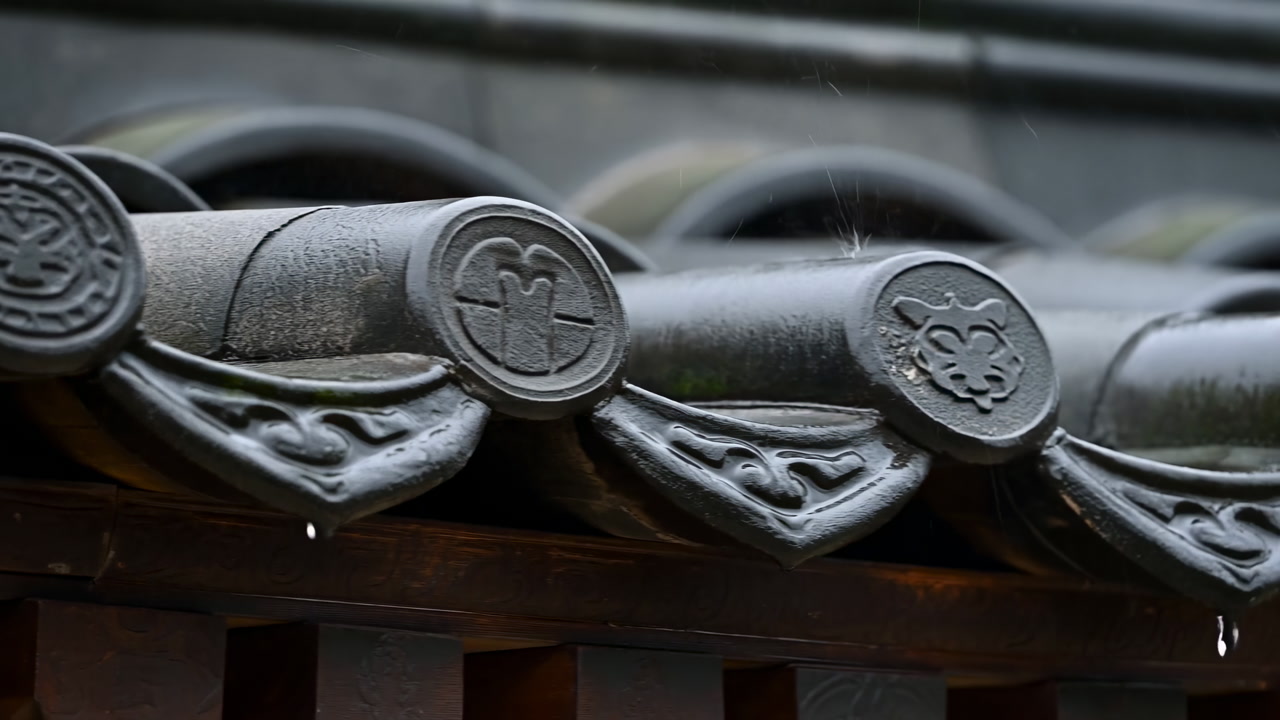 Closeup Japanese Roof Tiles Reveal Weathered Ceramic Eaves With Engraved Crest Motifs And Subtle Moss, Muted