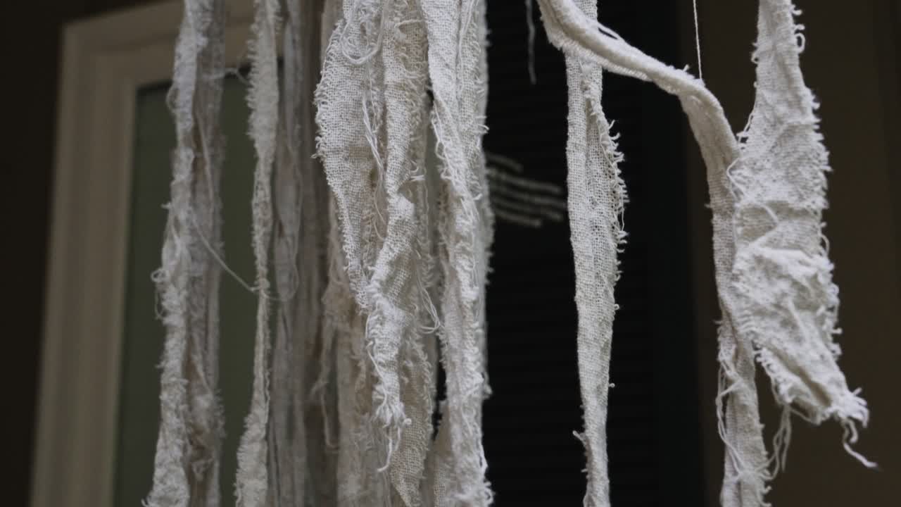 Spooky Season decor with makeshift fabric strips to look like a mummy's ghost blowing in the wind