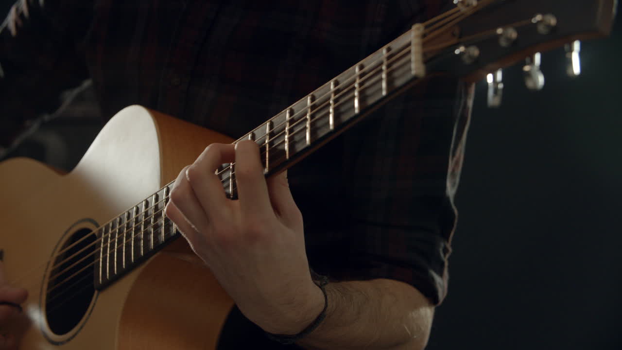Ripresa al rallentatore di un uomo che suona la chitarra acustica