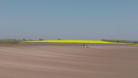 tractor working in a field of rapeseed
