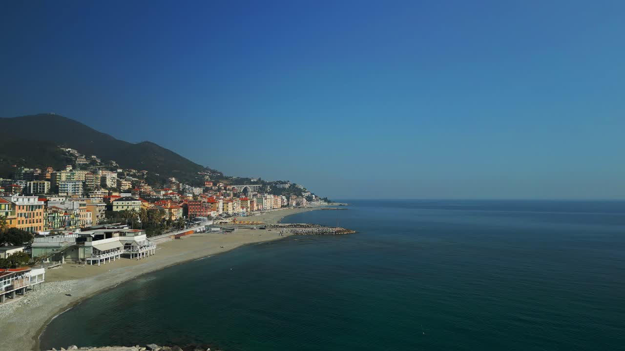 Ripresa aerea in ascesa sopra la costa con le pittoresche case della città ligure, Varazze, Italia