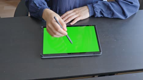 young female hands sketching on tablet with digital pencil, at wooden desk