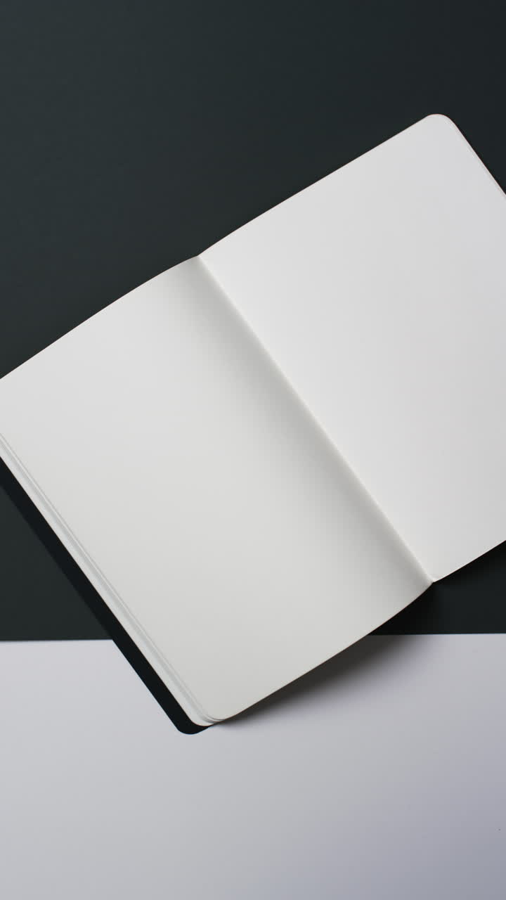 Vertical video of book with white blank pages and copy space on black background