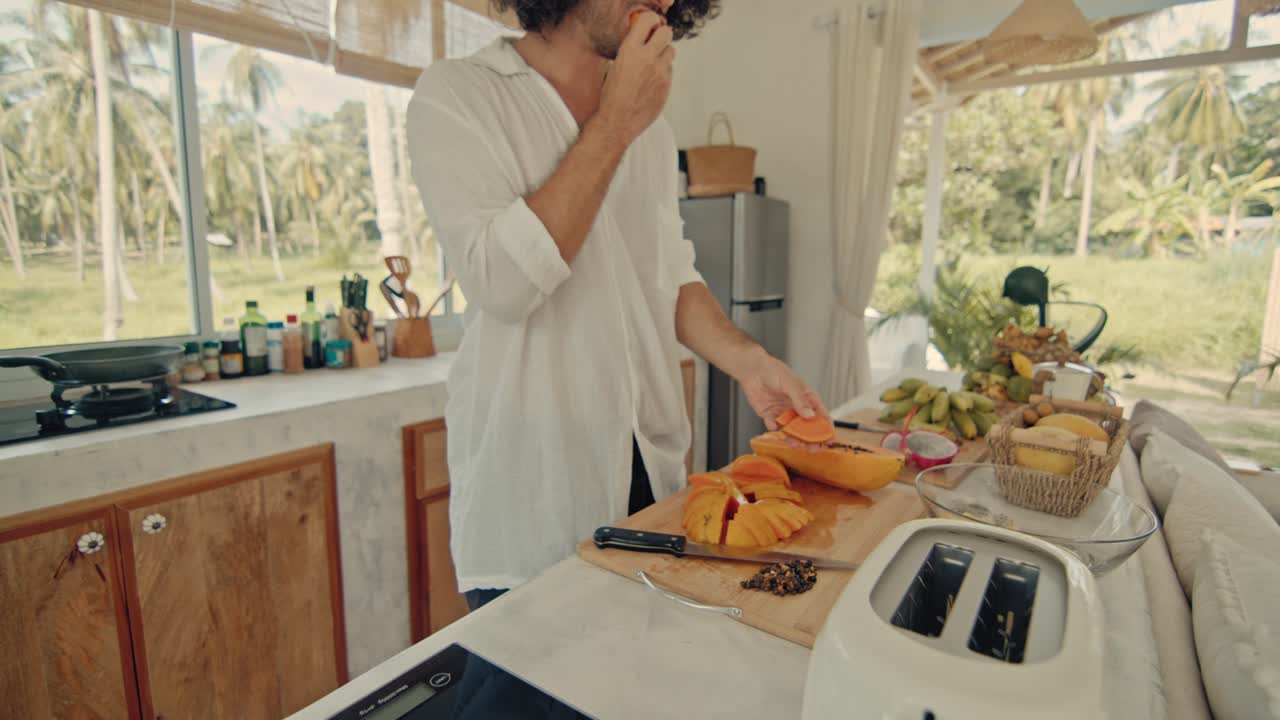 Man Cooking Tropical Fruits in a Cozy Kitchen