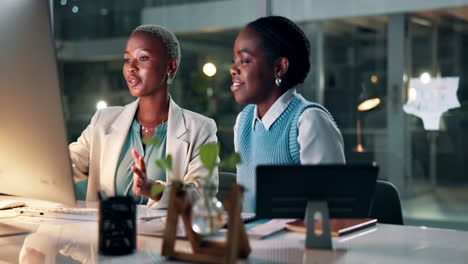 two women collaborating on a project at night