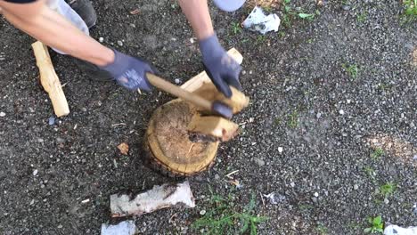 unrecognizable man splitting the wood with an ax