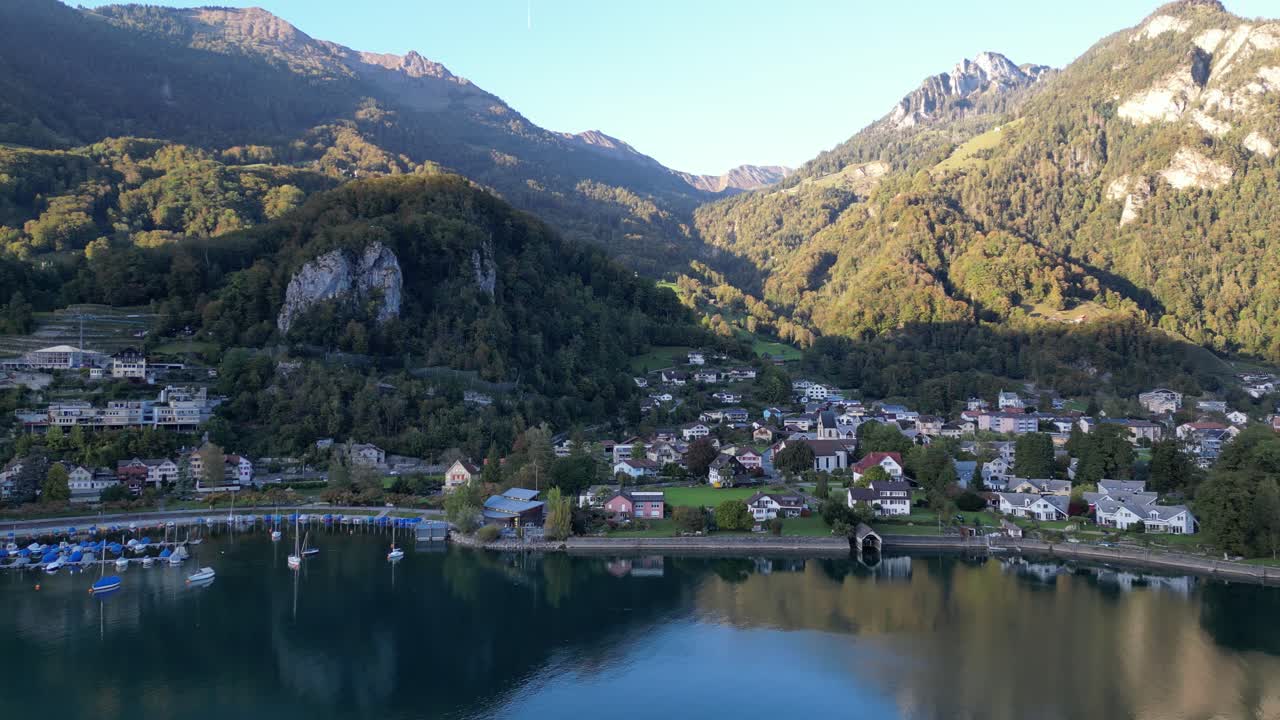 vista aérea de un pueblo suizo ubicado en la base de los majestuosos alpes, con vistas a las aguas azules marinas de walensee