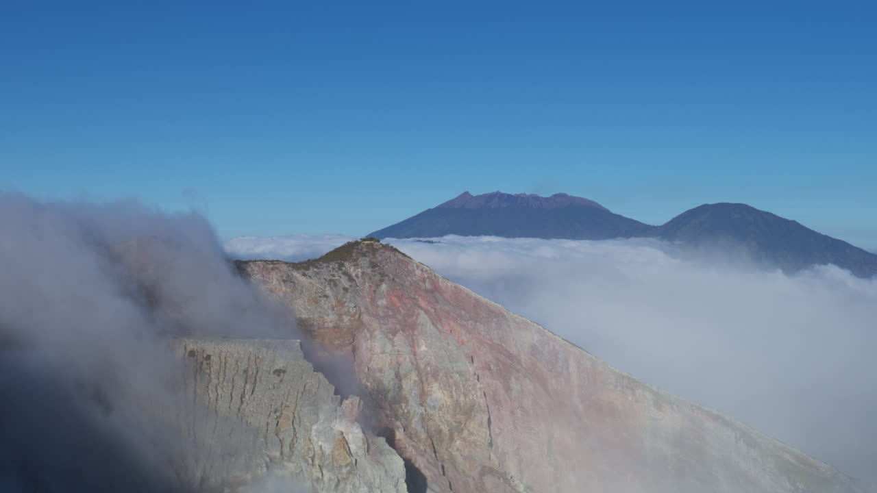 acantilado de nubes que se vierten en el creador del volcán en el monte ijen, java oriental, indonesia