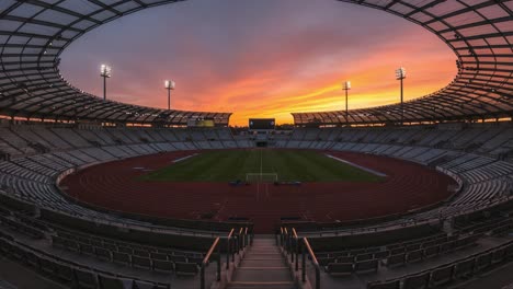 panoramic view of an empty stadium at sunset: a serene atmosphere with colorful skies above, illuminated by stadium lights for upcoming events