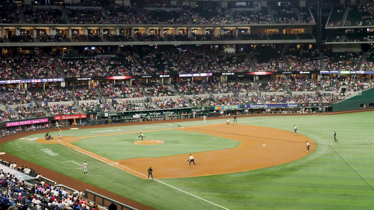 Slow motion landscape of huge crowd audience at major league baseball game with players running on pitch in stadium Arlington Texas USA America sports event