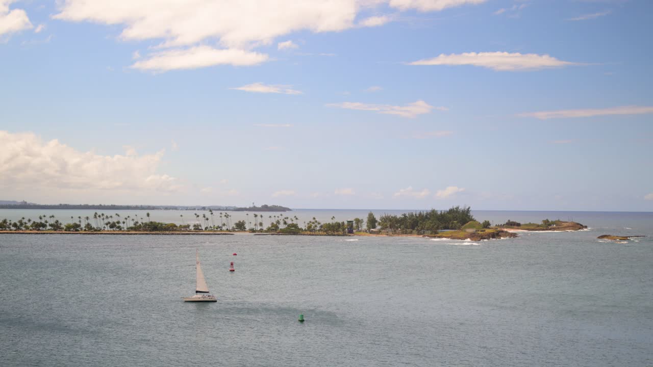 Aerial drone view of a boat with a small island off in the distance.