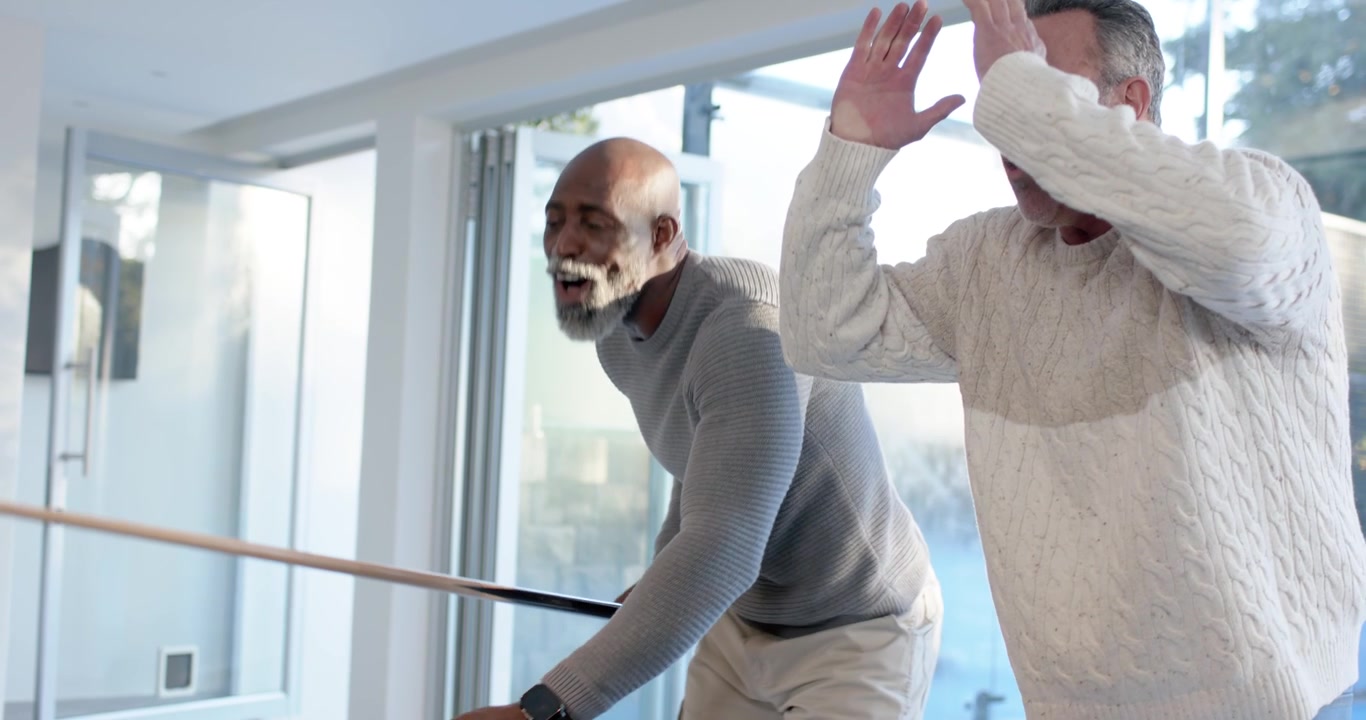 Mature African American man taking turn, leaning over dark-felt pool table, aiming cue to sink ball