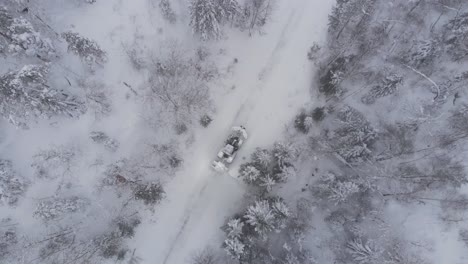 Bird's-Eye-View-Of-A-Working-Tractor-Clearing-Road-Covered-In-Snow