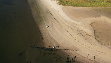 aerial-drone-camera-pan-forward-tilt-down-over-Shell-Bank-Creek-in-Brooklyn,-with-the-creek-shore---water-in-view-with-fisherman---his-kid