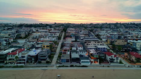 Toma-Aérea-De-Seguimiento-Del-Distrito-De-Manhattan-Beach,-Puesta-De-Sol-En-Los-Ángeles,-Estados-Unidos.