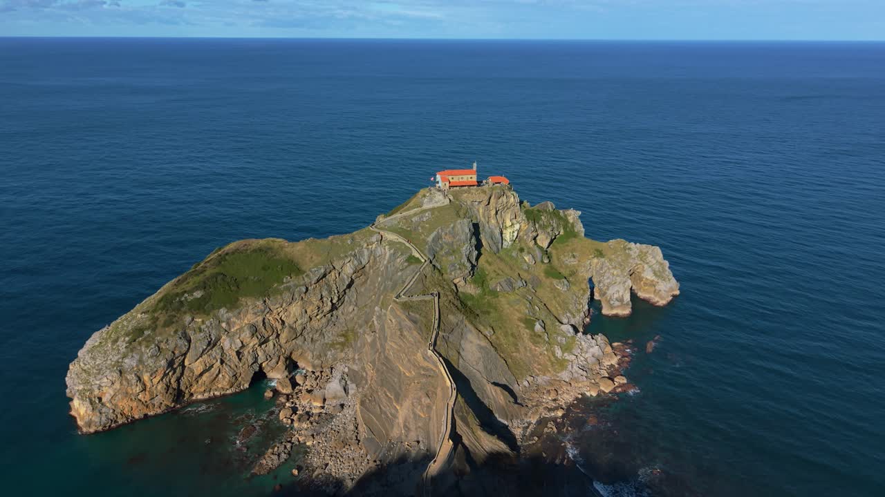 Isola di San Juan de Gaztelugatxe con chiesa costiera e ripidi gradini in pietra circondata dal mare, ripresa aerea