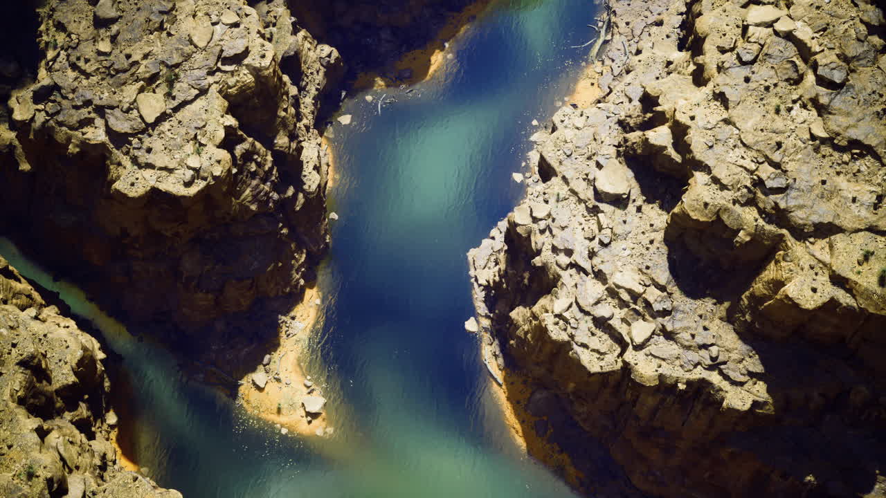 Serene river winding through rocky canyon under clear sky