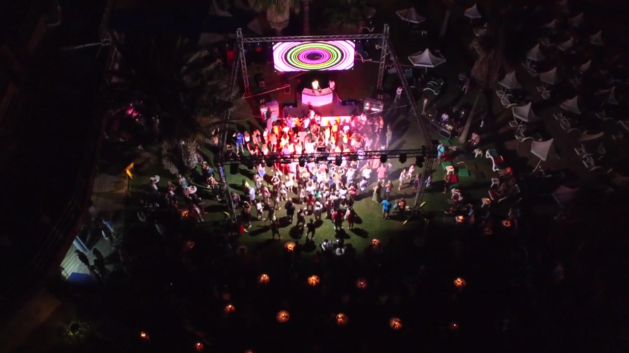 Luchtfoto van een dansende menigte in een openluchtnachtclub.