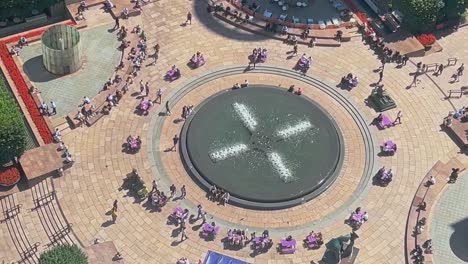 clip aéreo de la plaza de la ciudad donde se puede ver a la gente relajándose en la hora del almuerzo