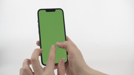 female hands using smart phone with vertical green screen on white background