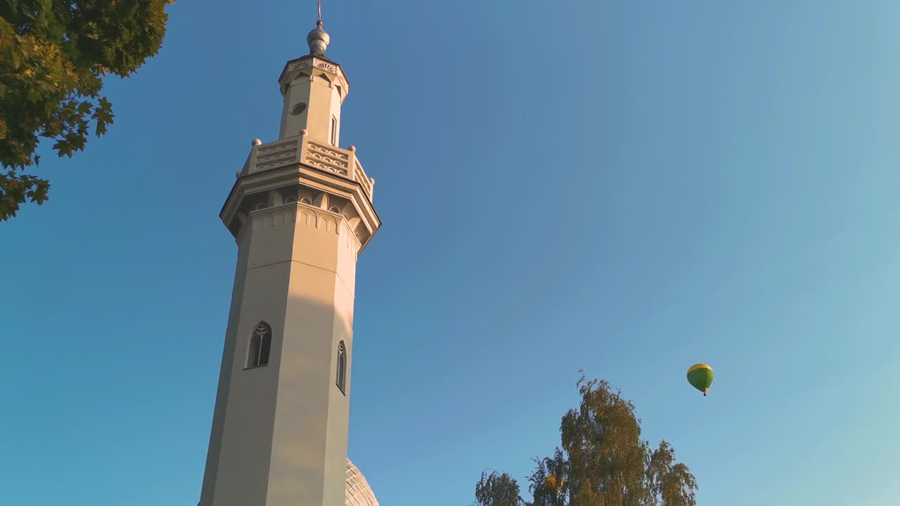 Air balloons flying flying in horizon over mosque