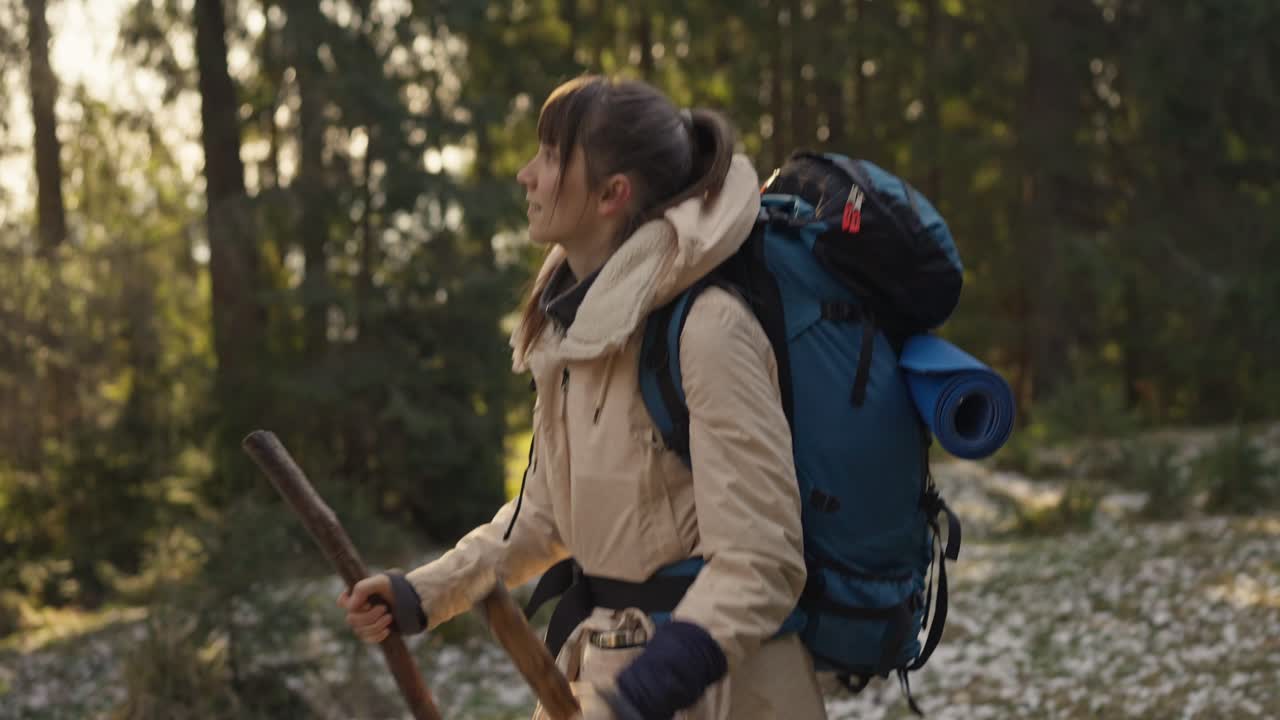 A woman hiking in a forest with a backpack