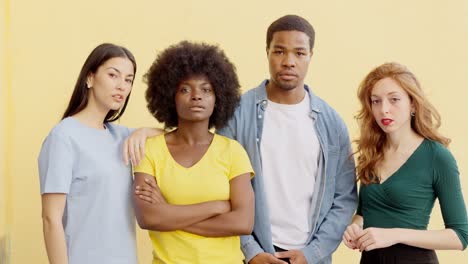 diverse group of young adults standing together with serious expressions