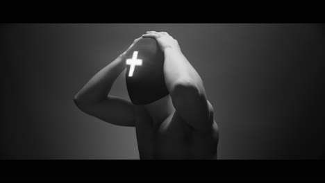 masked man with cross of light glowing on his face moves slowly