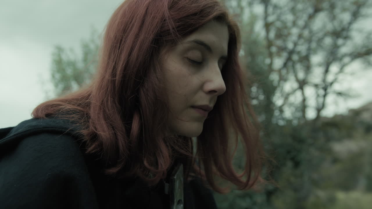 mujer reza en silencio religión cristiana con jesús crucificado en las montañas