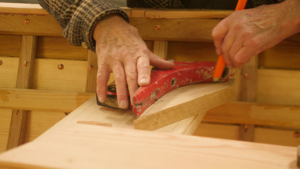 Carpenter templating old boat knee shape to new oak