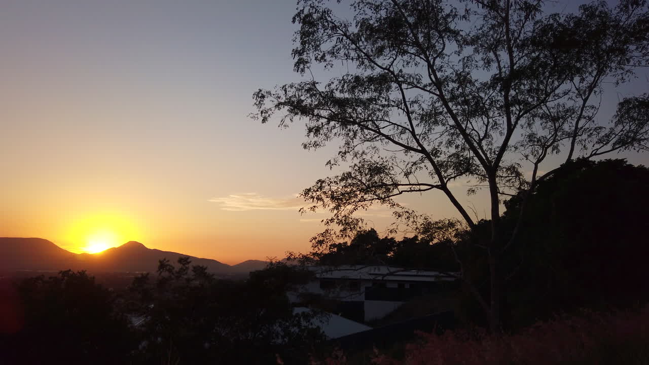 오렌지색 하늘에서 산 위에 떠오르는 태양