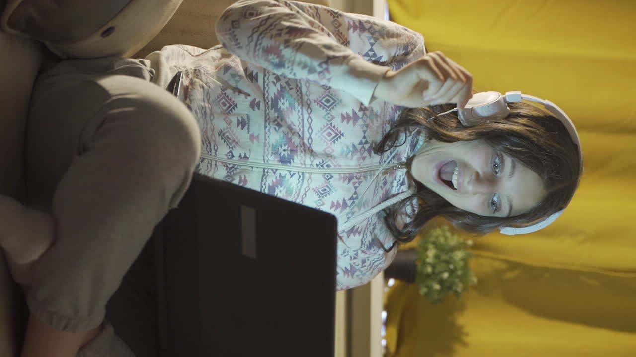 vídeo vertical de un estudiante varón que está feliz de que sus resultados de examen son buenos. en casa por la noche.