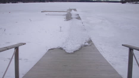 wooden boardwalk path leading across snow covered woodland lake at holiday club katinkulta vuokatti finland