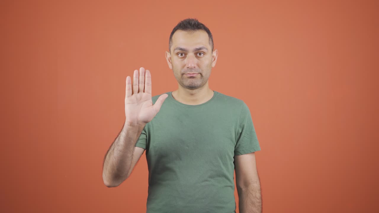 un hombre de negocios dice "deténgase" a la cámara.