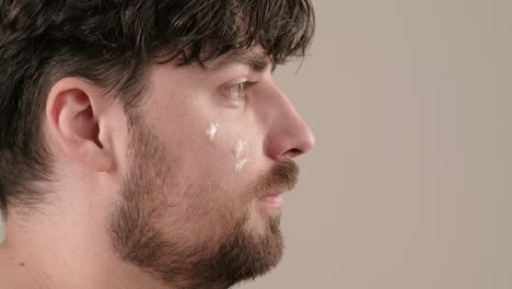 hombre aplicando crema facial