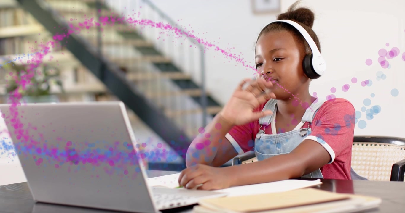 Estudante sentado à mesa, aula sendo reproduzida no laptop, estudo em evolução enquanto partículas rosa e azuis se movem