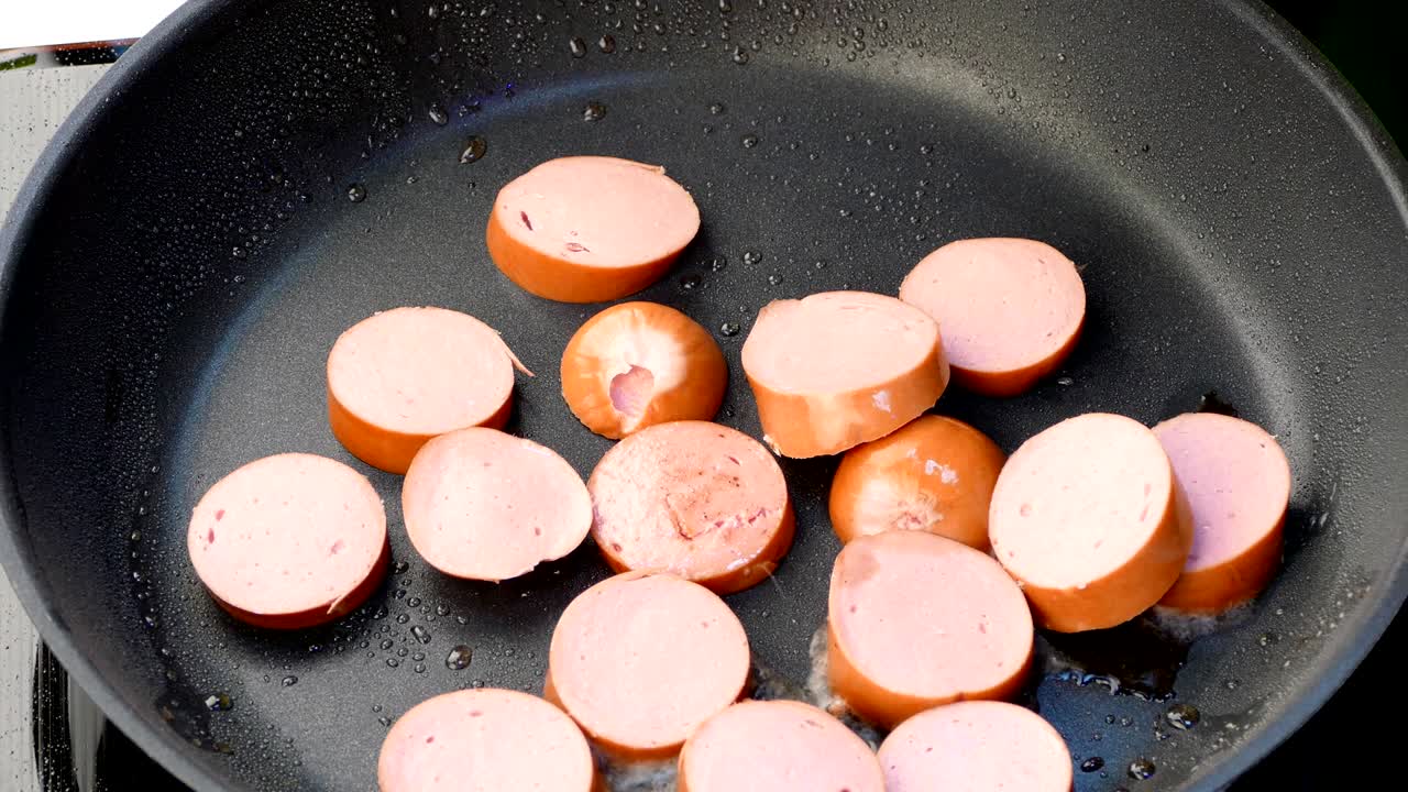 el chef lanza salchichas picadas en una sartén