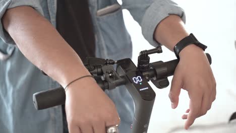 primer plano de una persona que sostiene un scooter eléctrico