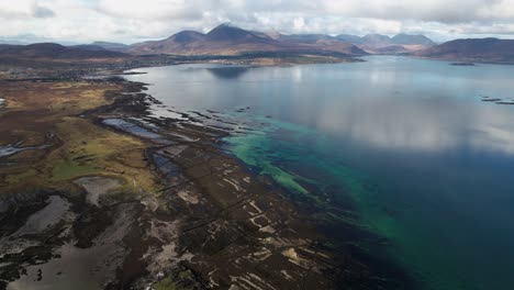 bella reflexión sobre el paisaje montañoso en la bahía azul claro de broadford en la isla de skye