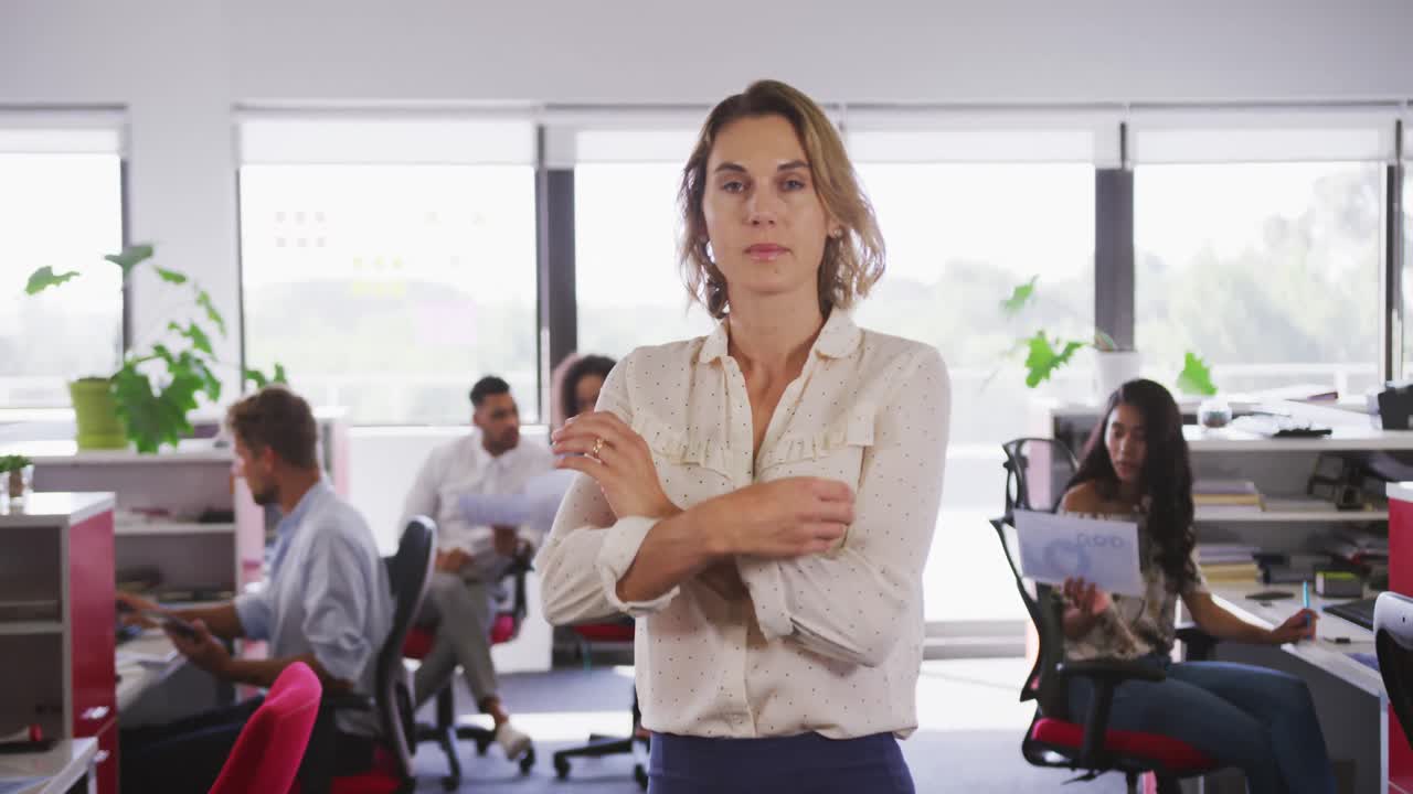 Donna d'affari professionista in piedi con le braccia conserte in un ufficio moderno al rallentatore