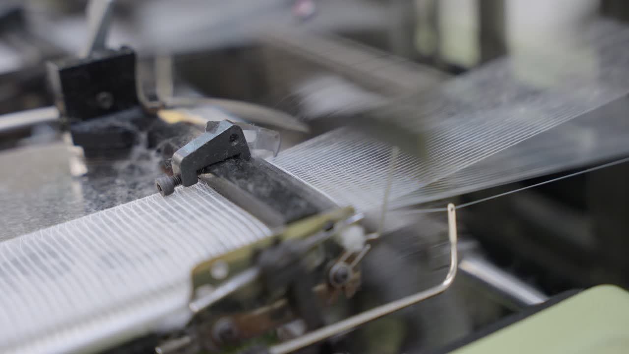 Close up Loom machine in action, showcasing threads, moving parts, and the weaving process, ideal for textile manufacturing, craftsmanship, industrial production, and machinery visuals
